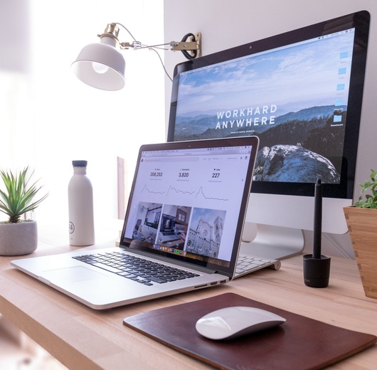 WebX studio workspace — laptop and desktop showing website designs